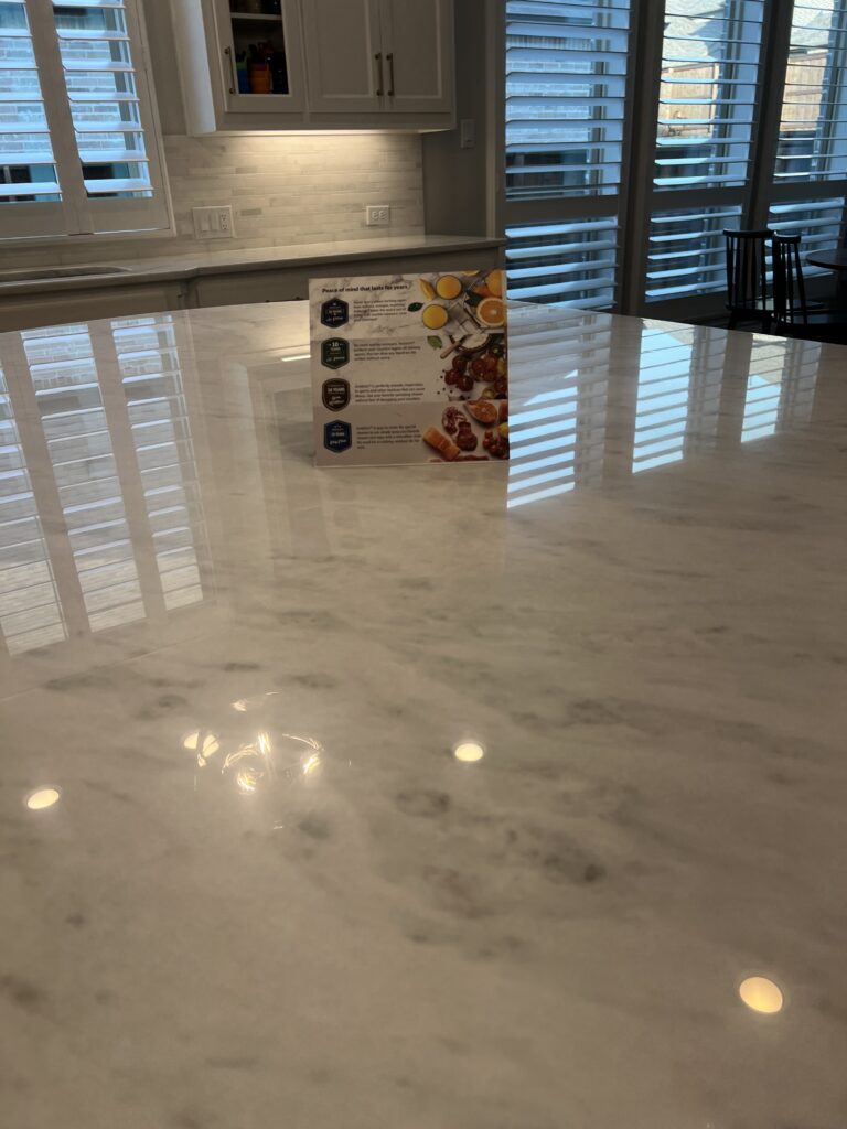 Technician applying MORE® AntiEtch® to a honed marble countertop in a luxury kitchen in Southlake, TX.
