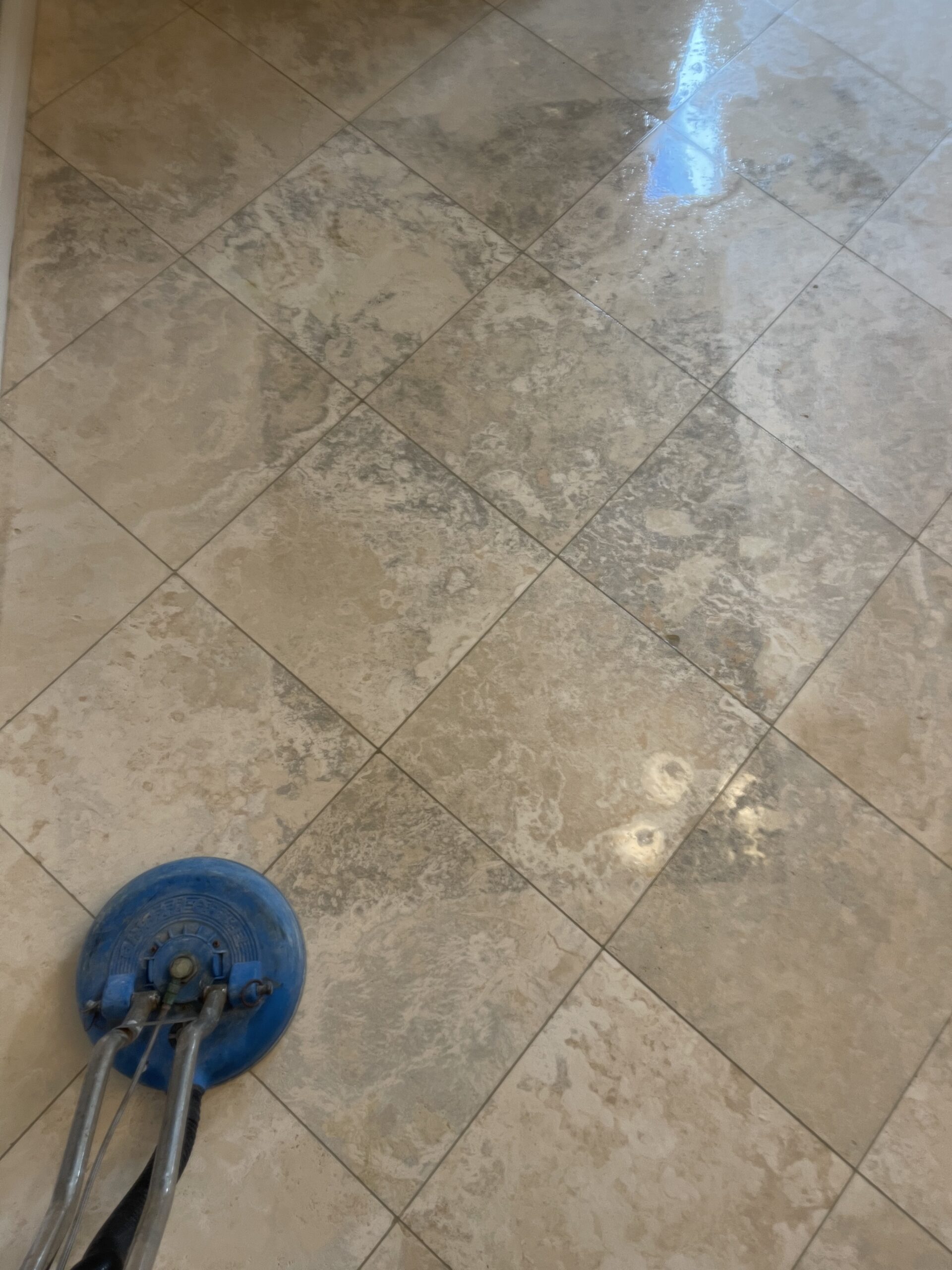 Technician deep-cleaning and polishing a travertine floor in a residential Studio City home, restoring the natural finish.