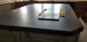 A marble countertop treated with AntiEtch®, with a sample piece showing visible etching from acids, demonstrating the superior protection of AntiEtch®.