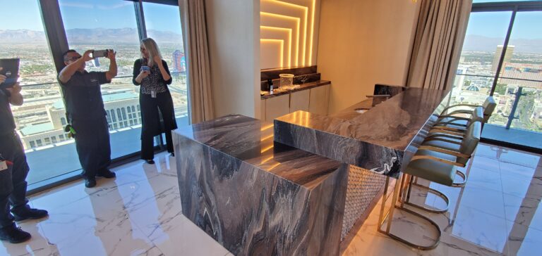 People taking photos of a newly applied AntiEtch® coating on a marble countertop in a hotel, showcasing its flawless, etch-resistant finish.