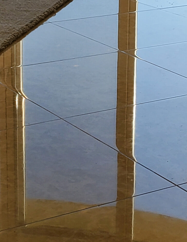 Polished marble floor in a Corona Del Mar home reflecting natural light after professional marble restoration by Sureshine Care and Restoration Services.