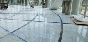 Technician polishing marble floors in a Summerlin home, restoring a glossy and reflective finish using professional-grade equipment.