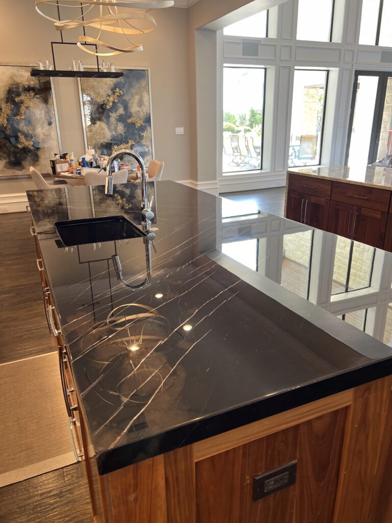 Sureshine technician polishing a marble countertop in a luxury Southlake kitchen, restoring high-gloss reflection.