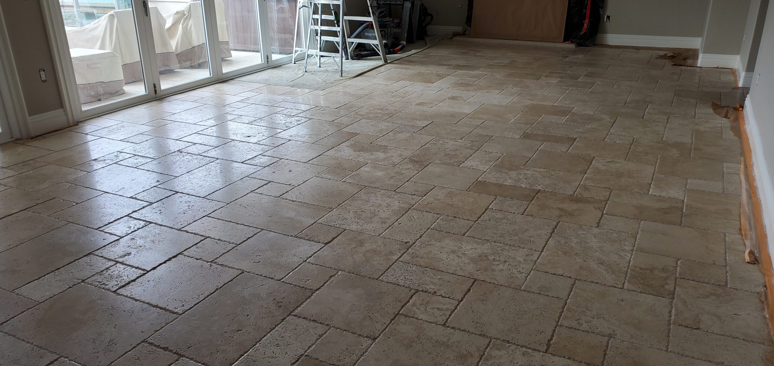 Sureshine technician polishing travertine floors in a Frisco, TX home to restore smoothness and natural shine.