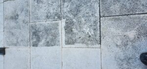 Sureshine technician deep cleaning a travertine floor in a Frisco, TX home using hot water extraction