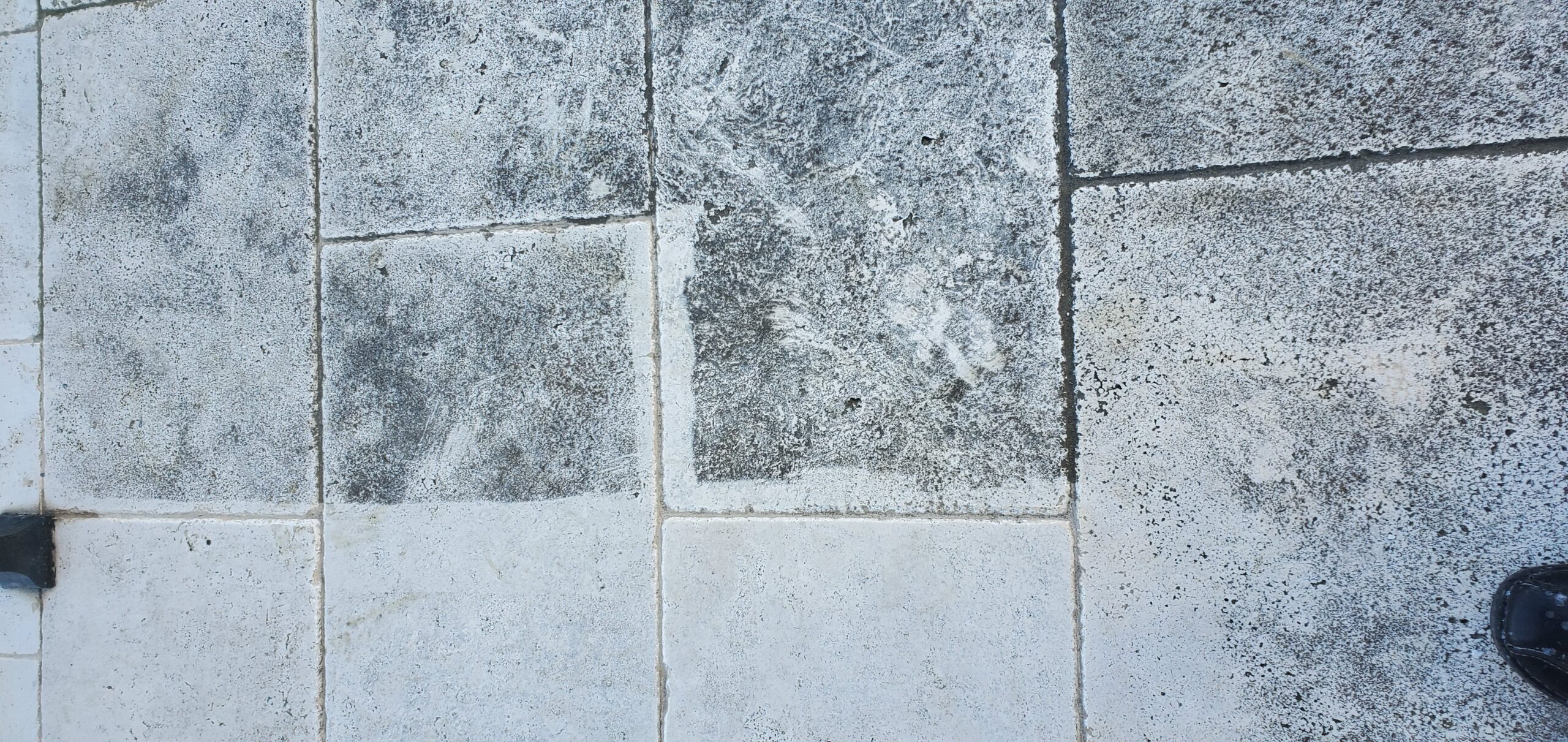 Sureshine technician deep cleaning a travertine floor in a Frisco, TX home using hot water extraction