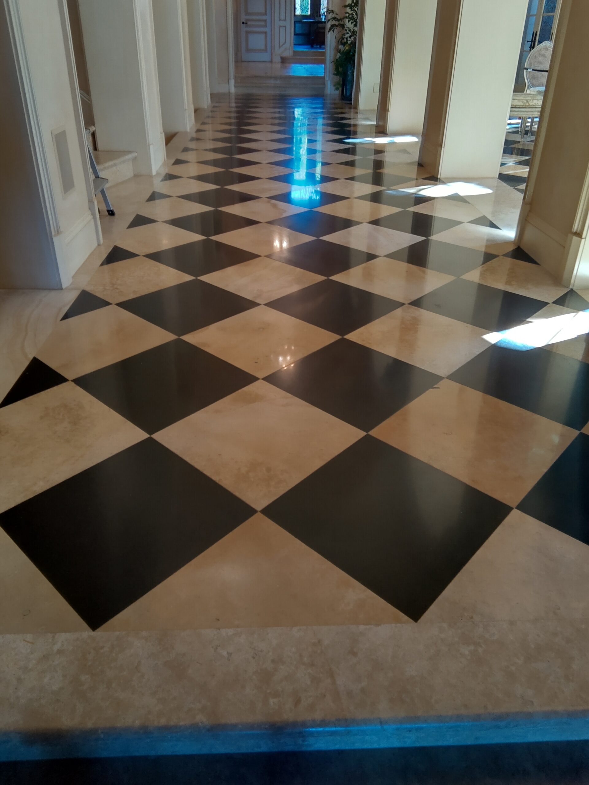 Technician deep cleaning marble floor in a Plano, TX home using stone safe hot water extraction