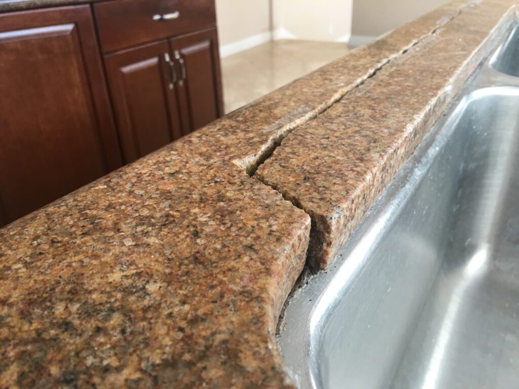 Sureshine technician repairing a cracked granite sink rail in a Pacific Palisades kitchen