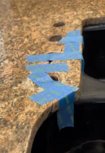 Sureshine technician repairing a cracked granite sink rail in a Southlake, TX kitchen