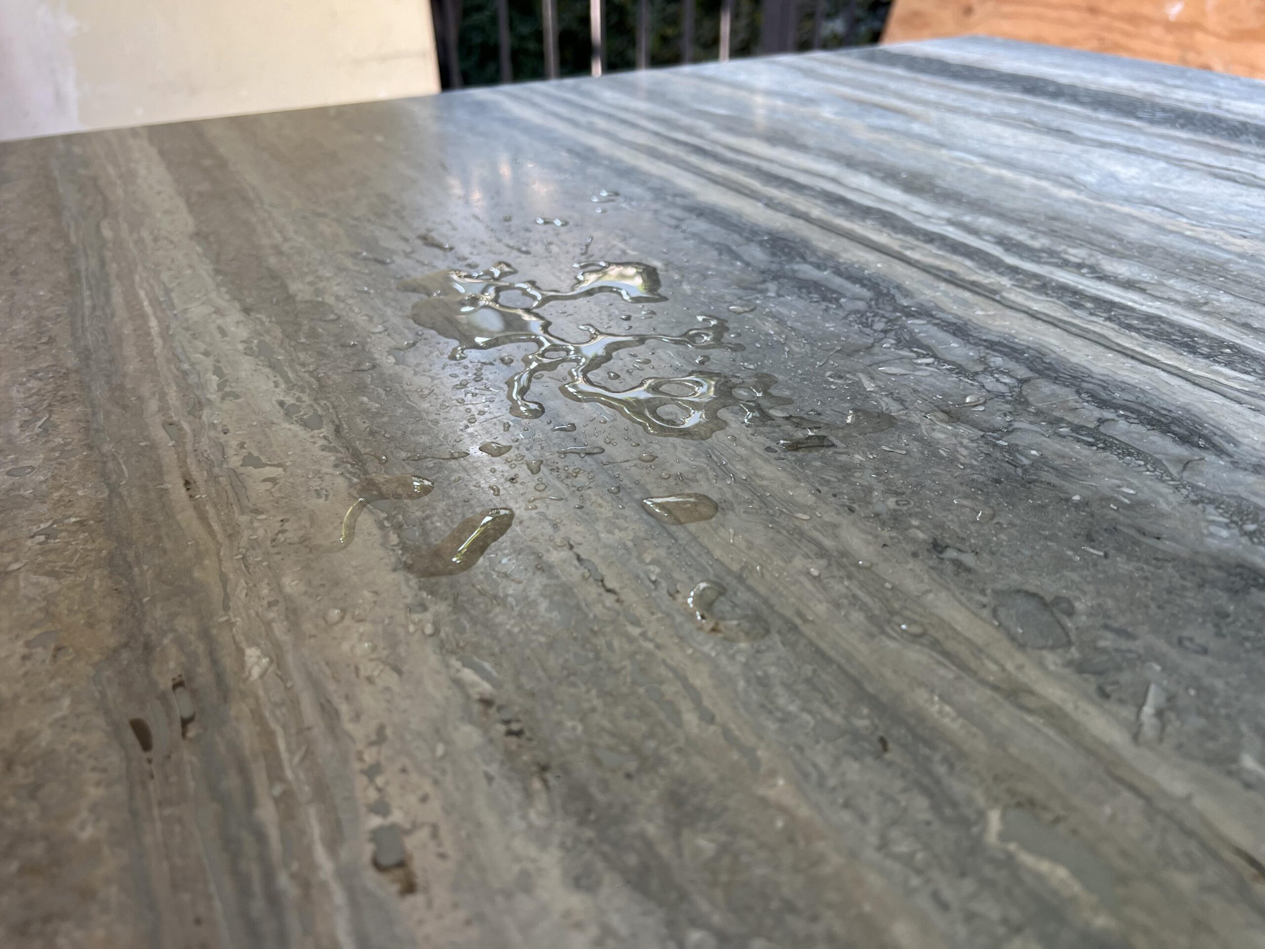 Before and after image of travertine tile floor cleaning in Dana Point, showing deep soil removal and restored natural stone color.