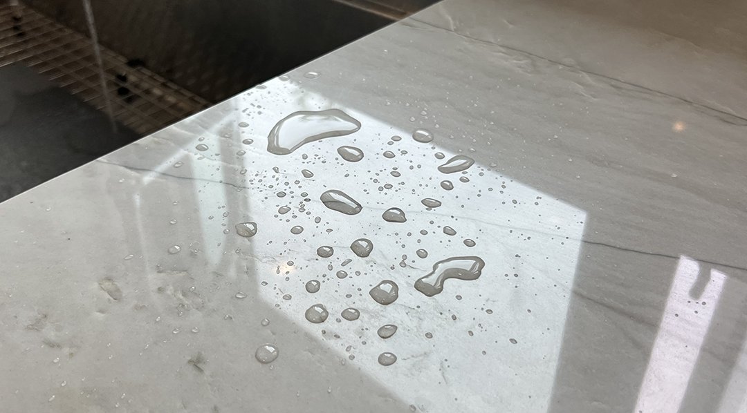Water beading on a quartzite countertop sealed with EnduraShield® by Sureshine — visible proof of seal effectiveness on natural stone